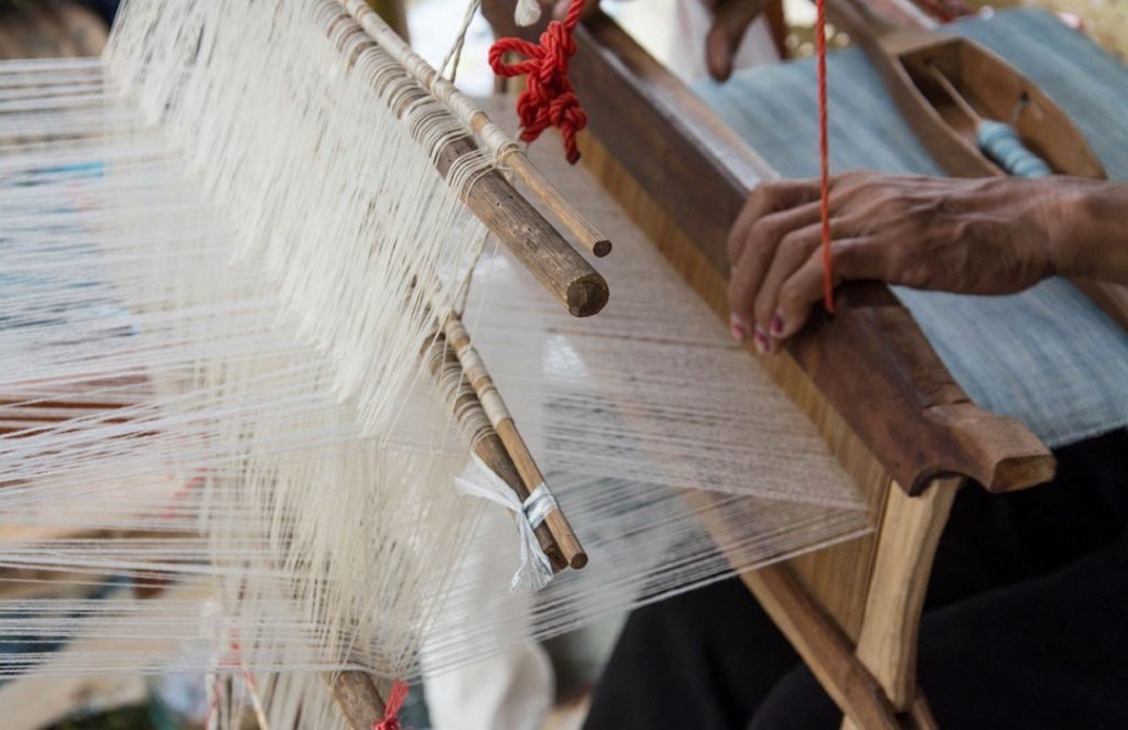 a weaver's hands at the loom - adivalka ikat cotton - textiles of India